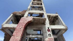 In ruins: A boy stands in the shell of the parliament building in Somalia. Photo: Reuters 